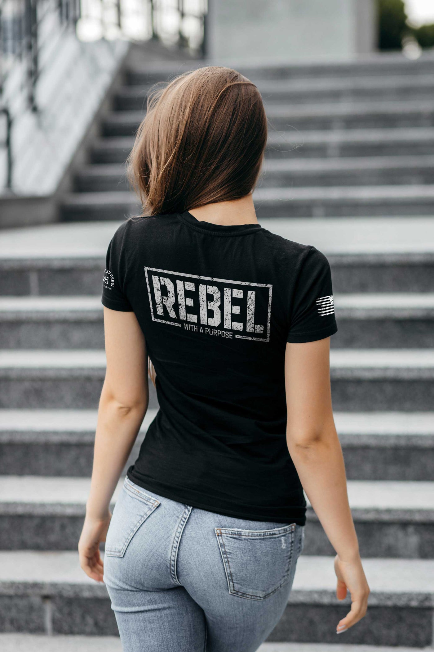 Woman wearing Solid Black Women's Rebel With A Purpose Back Design Tee