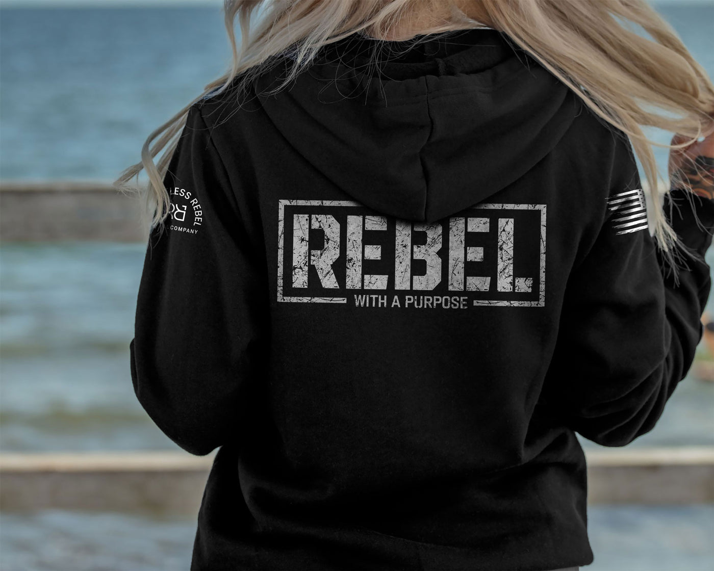 Woman wearing Solid Black Women's Rebel With A Purpose Back Design Hoodie