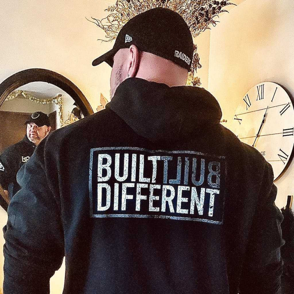 Man wearing Solid black back design men's Built Different hoodie