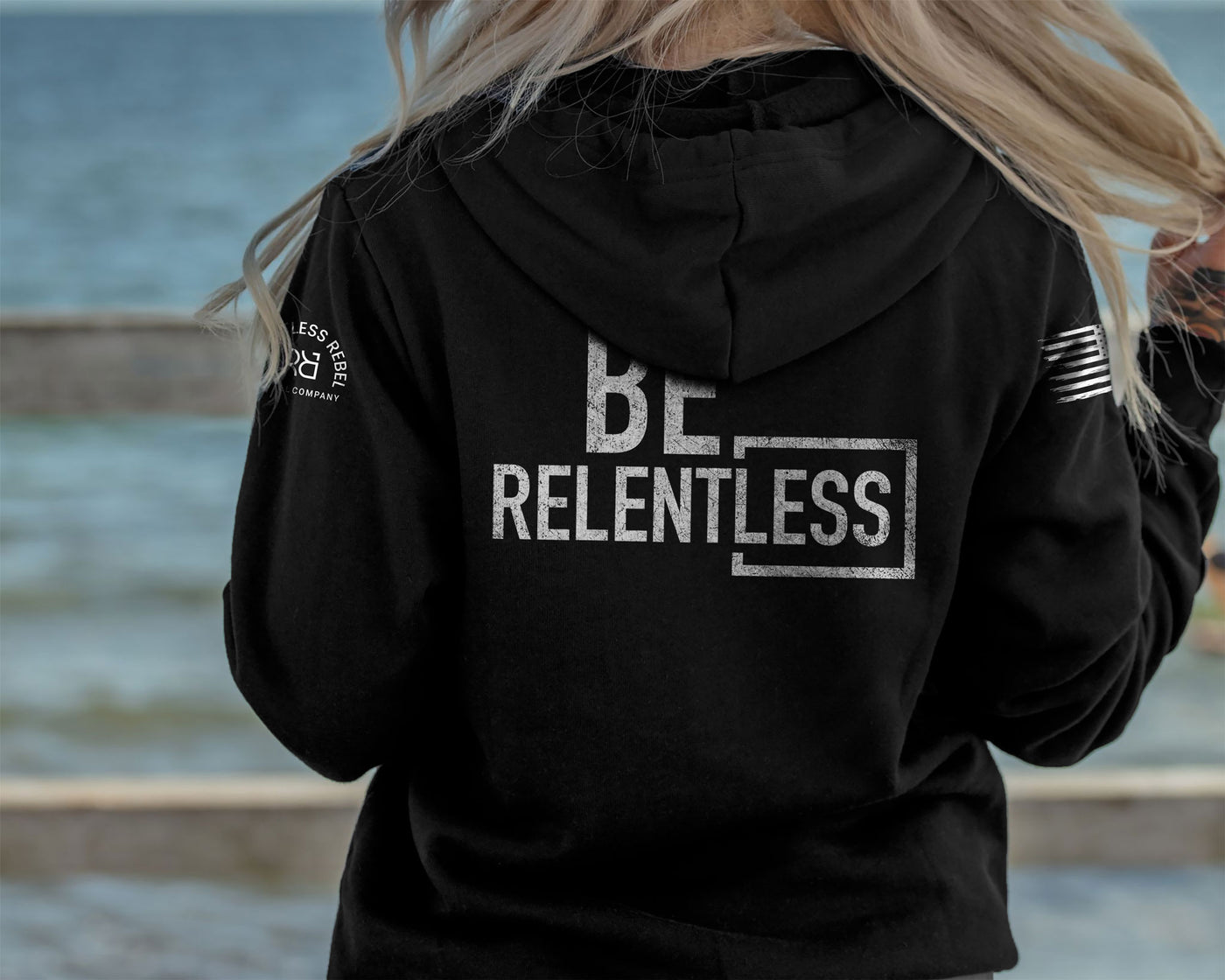 Woman wearing Solid Black Women's Be Relentless Back Design Hoodie