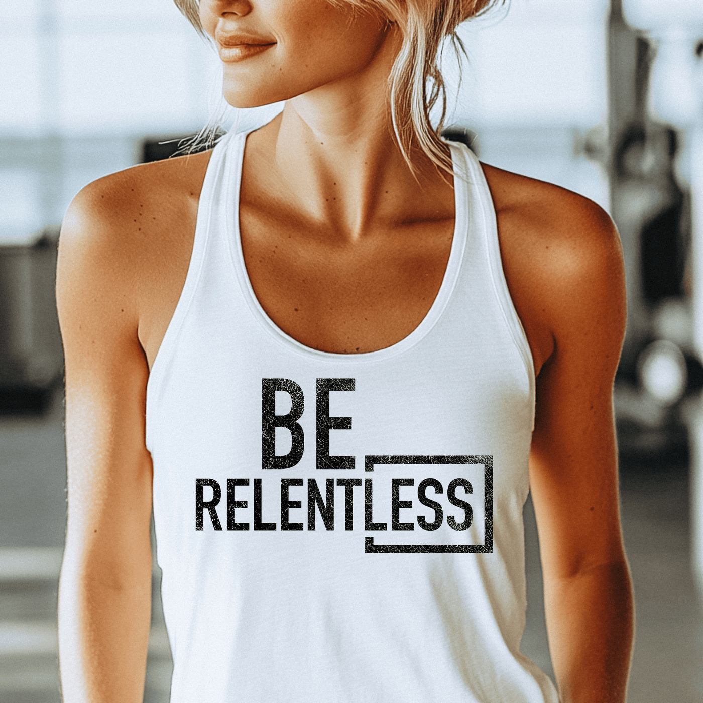 Person wearing a white tank top with 'BE RELENTLESS' text in a gym setting
