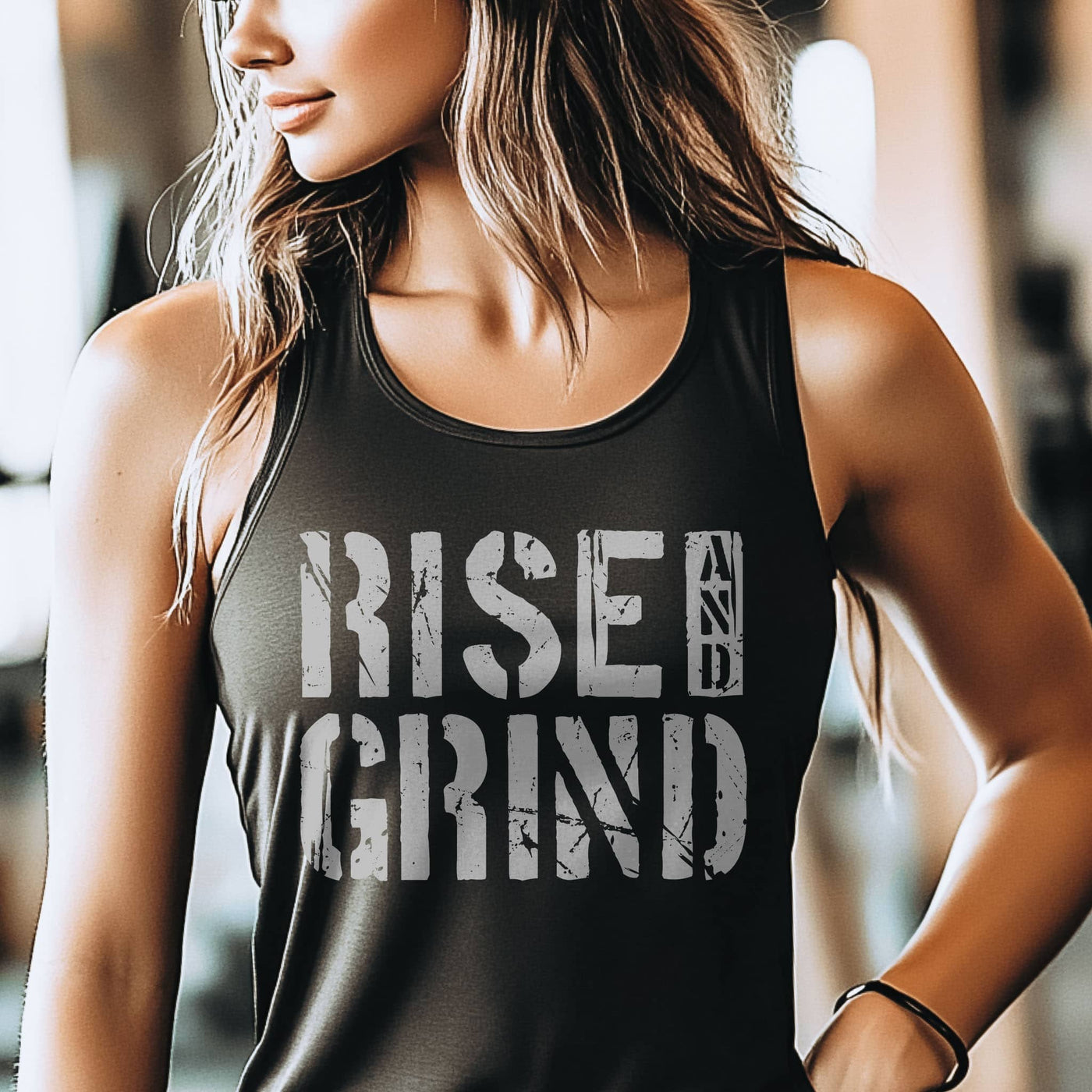 Person wearing a black tank top with 'Rise and Grind' text in a gym setting