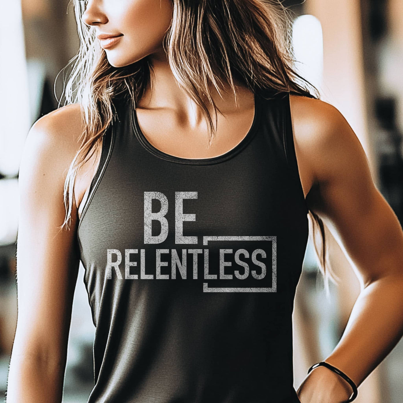 Person wearing a black tank top with 'BE RELENTLESS' text in a gym setting