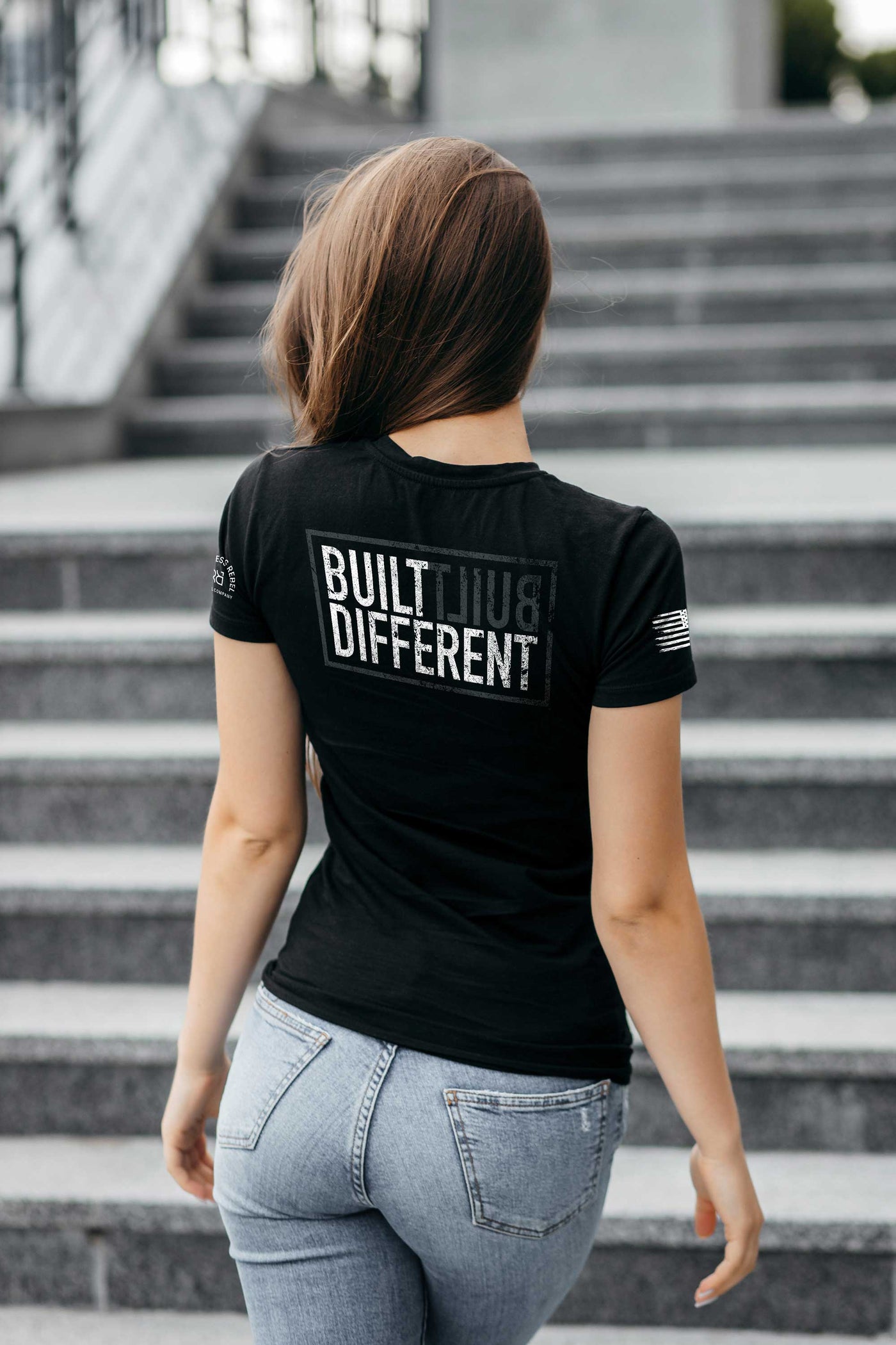 Woman wearing Solid black women's Built Different back design tee