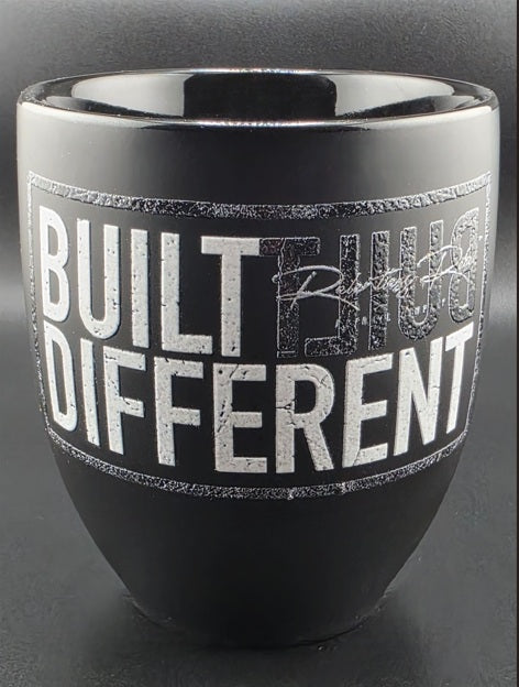 Black mug with 'Built Different' text on a dark background