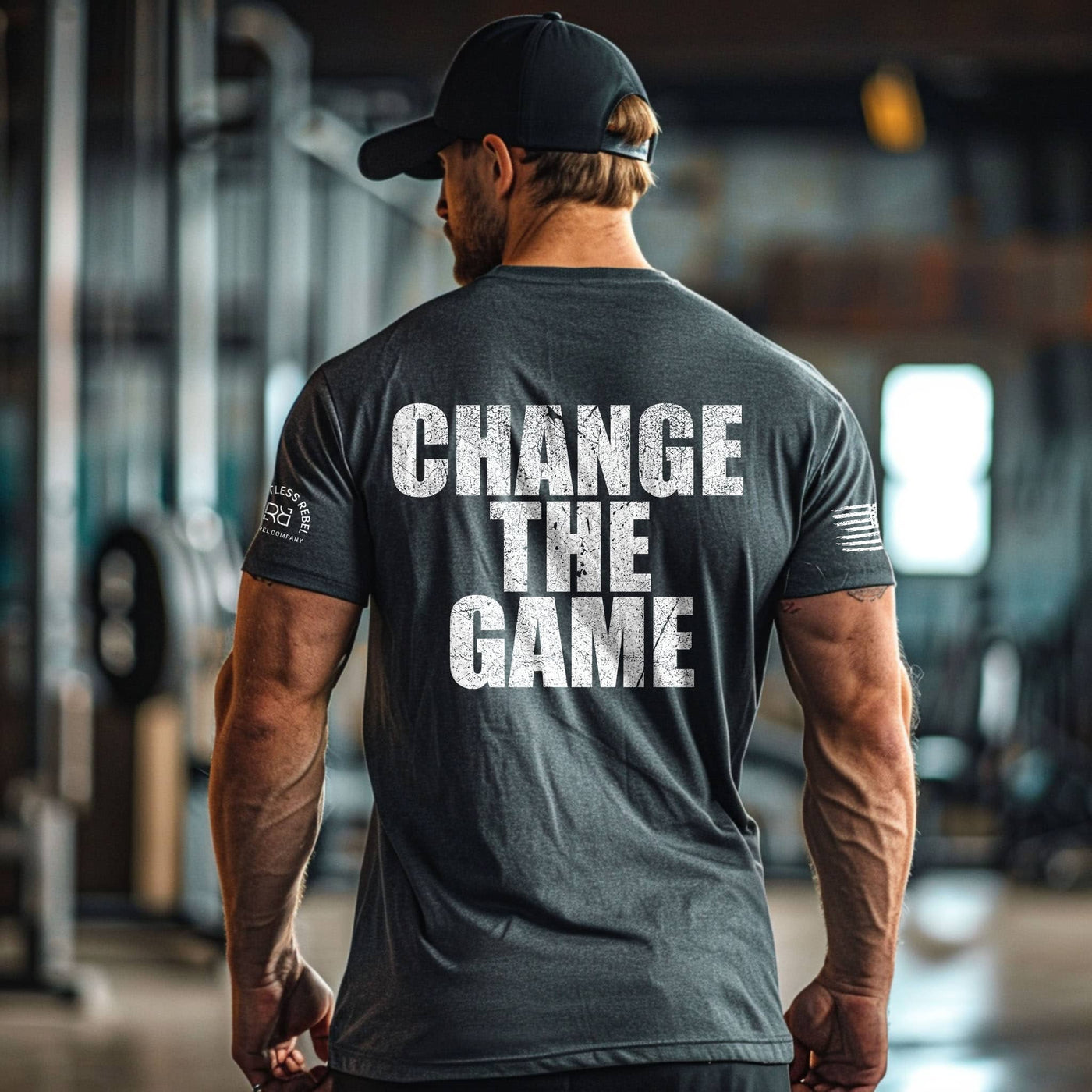 Man wearing a t-shirt with 'CHANGE THE GAME' text in a gym setting