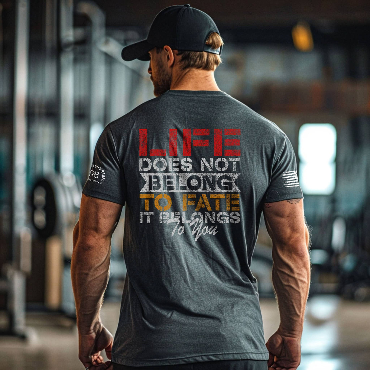 Man wearing a motivational t-shirt with text in a gym setting