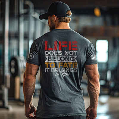 Man wearing a motivational t-shirt with text in a gym setting