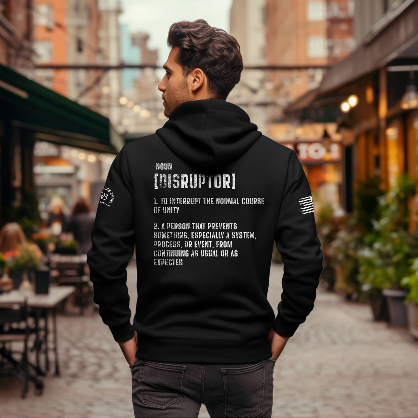 Person wearing a black hoodie with text on the back in an urban setting