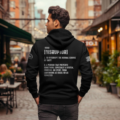 Person wearing a black hoodie with text on the back in an urban setting