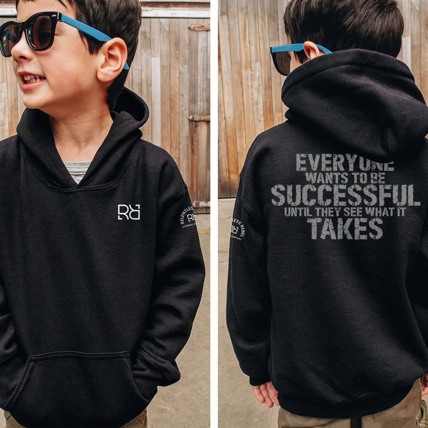 Child wearing a black hoodie with a logo on the front and motivational text on the back, standing in front of a wooden fence.