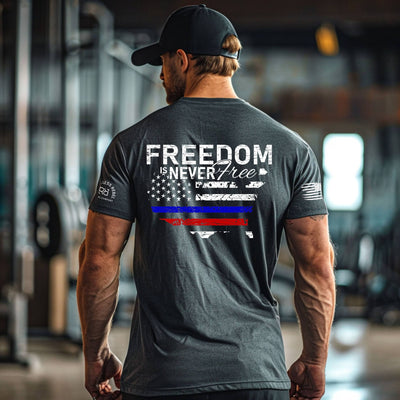Man wearing a t-shirt with 'Freedom is Never Free' design in an indoor setting