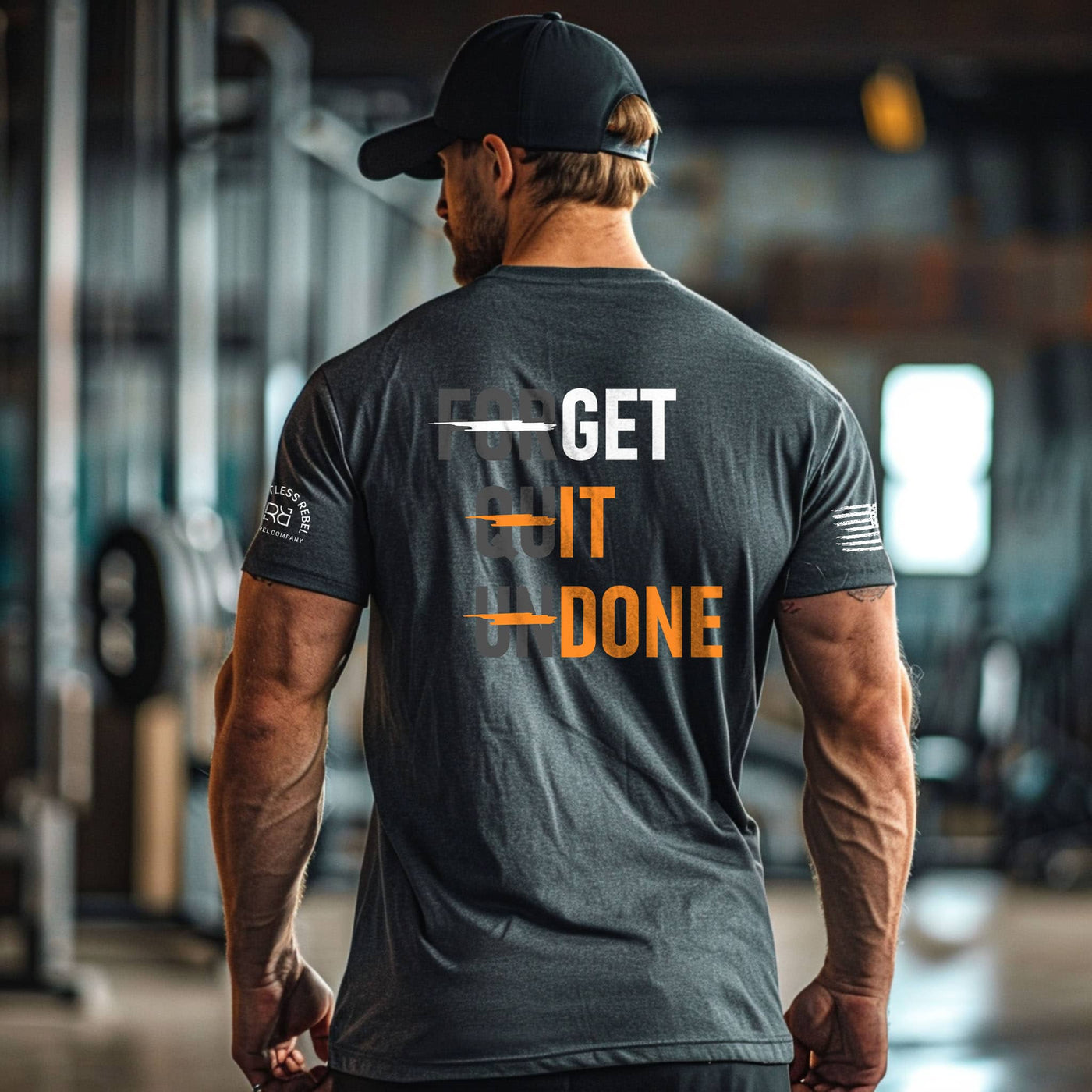Man wearing a gray t-shirt with 'GET IT DONE' text in a gym setting