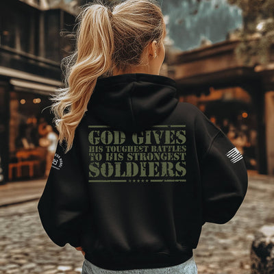 Person wearing a black hoodie with text on the back, standing outdoors.