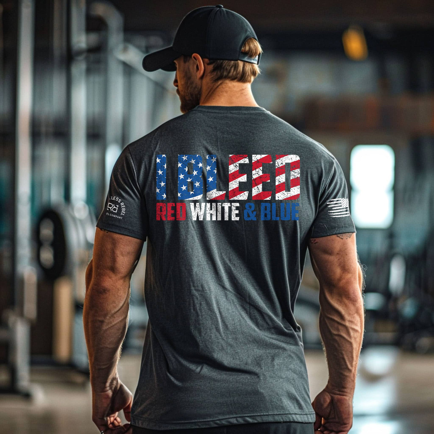Man wearing a gray t-shirt with 'I BELIEVE RED WHITE & BLUE' design in an indoor setting.