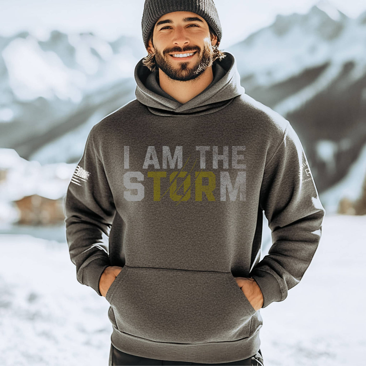 Man wearing a hoodie with 'I AM THE STORM' text in a snowy mountain setting