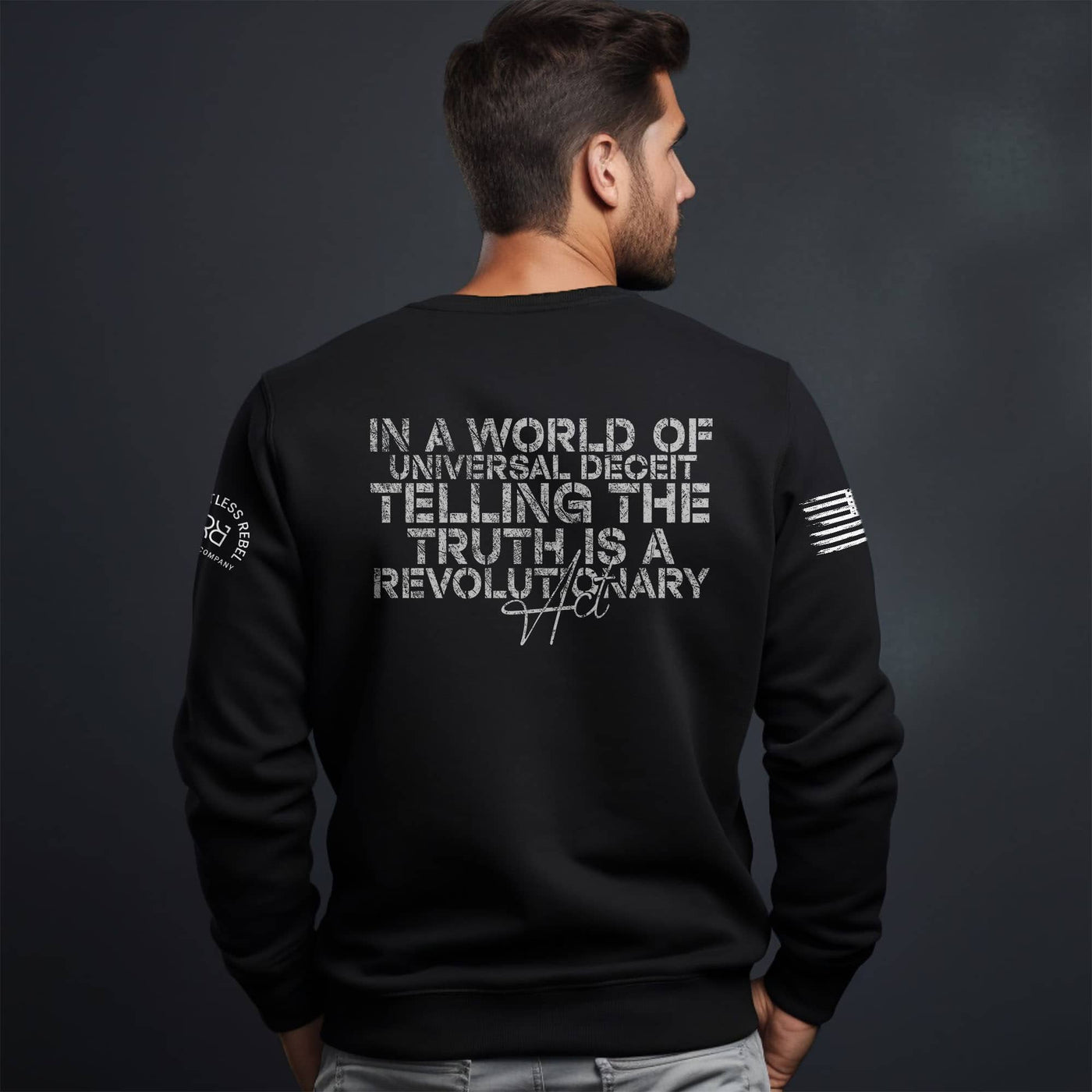Man wearing a black sweatshirt with text on the back against a dark background