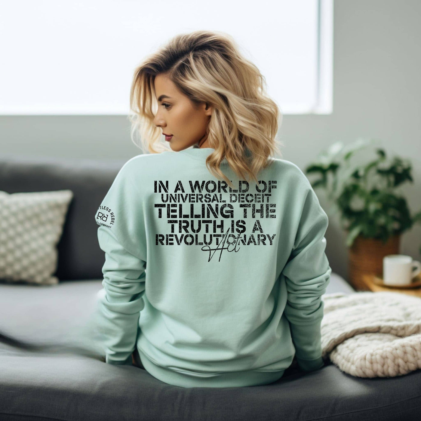 Woman wearing a light green sweatshirt with text in a living room setting