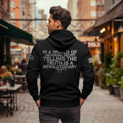 Person wearing a black hoodie with text on the back in an urban setting