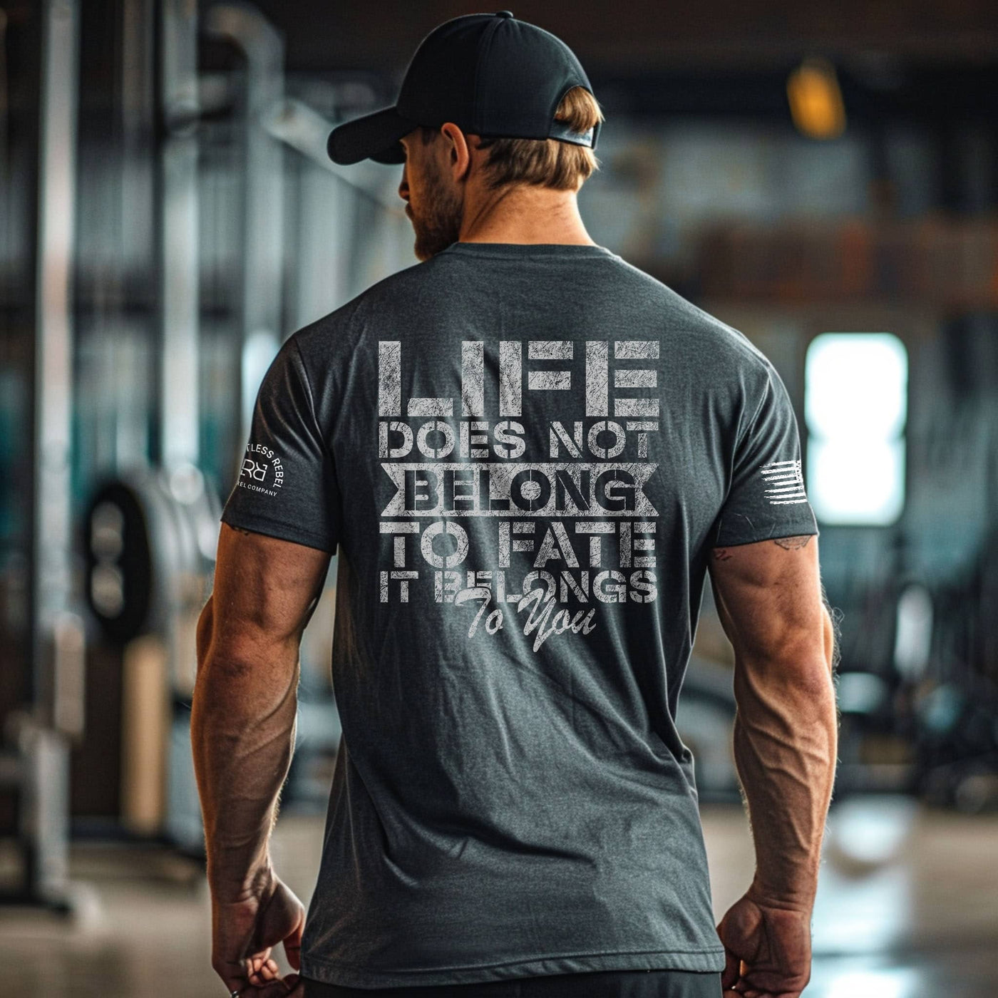 Man wearing a motivational t-shirt with text on the back in an indoor setting.