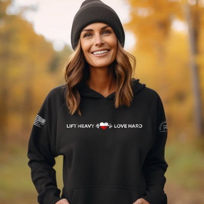 Woman wearing a black hoodie with motivational text in an autumn setting