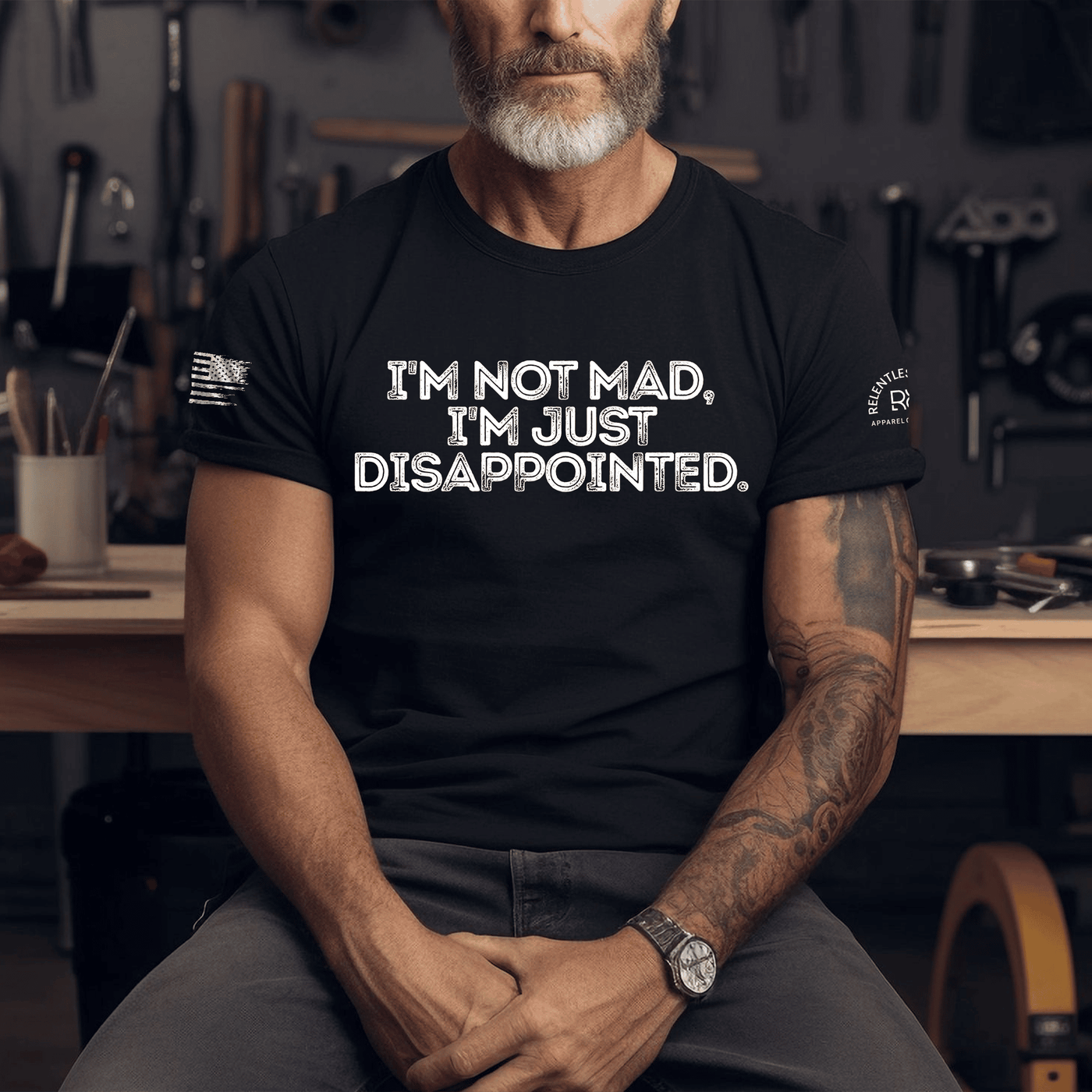 Man wearing a black t-shirt with text in a workshop setting