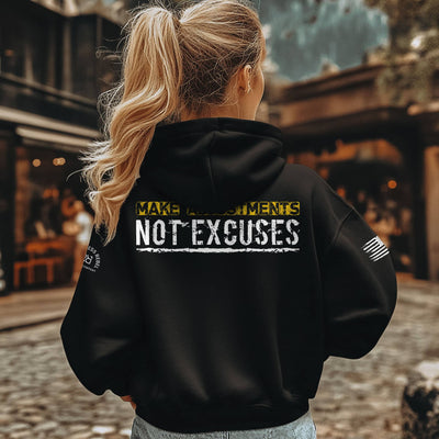 Person wearing a black hoodie with motivational text on the back, standing outdoors.