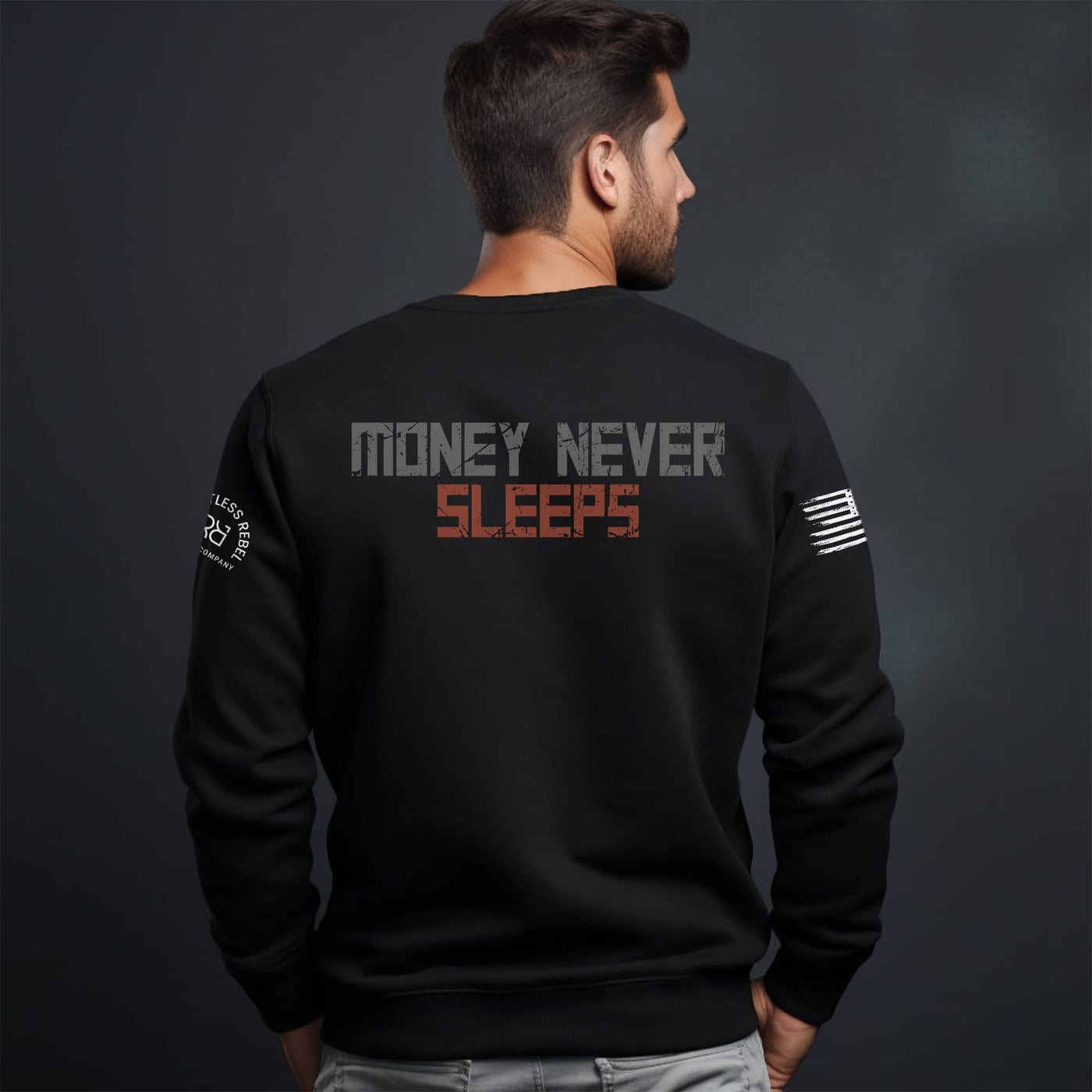 Man wearing a black sweatshirt with 'Money Never Sleeps' text on the back against a dark background