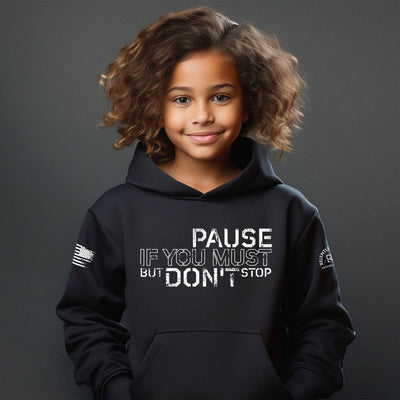 Child wearing a black hoodie with text on a dark background