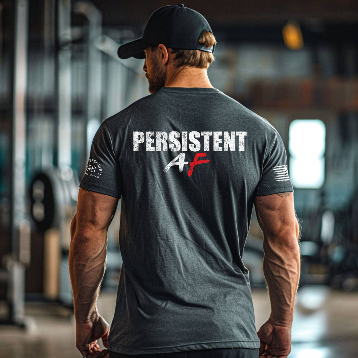 Man wearing a black t-shirt with 'PERSISTENT AF' text in an indoor setting