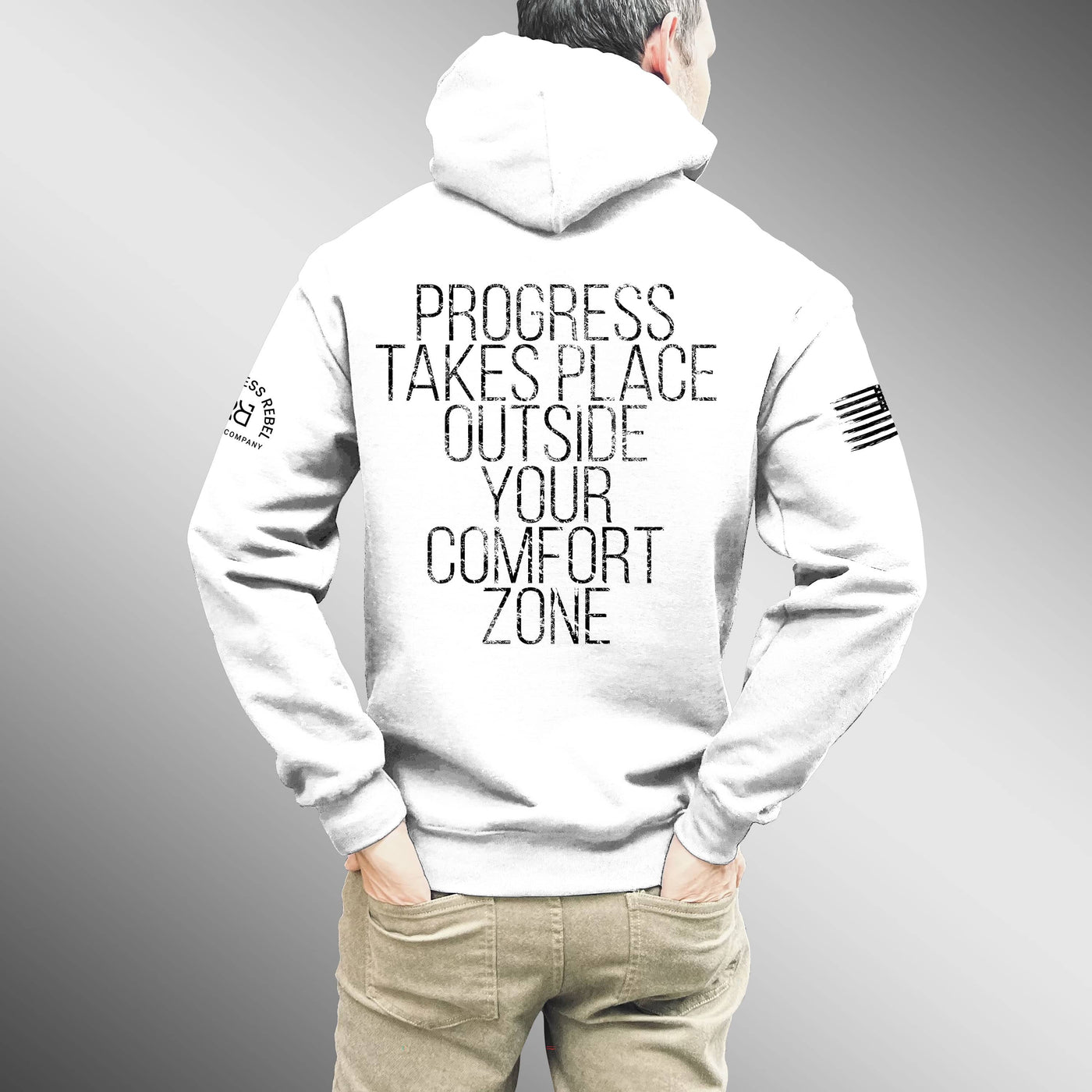 Person wearing a white hoodie with a motivational quote on the back against a gray background