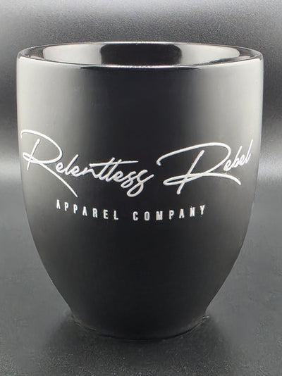 Black mug with 'Relentless Rebel Apparel Company' logo on a dark background
