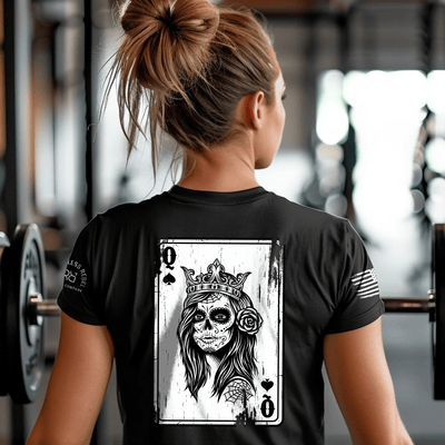 Person wearing a black t-shirt with a graphic design of a skeleton queen of spades in a gym.