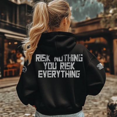 Person wearing a black hoodie with text on the back, standing outdoors.