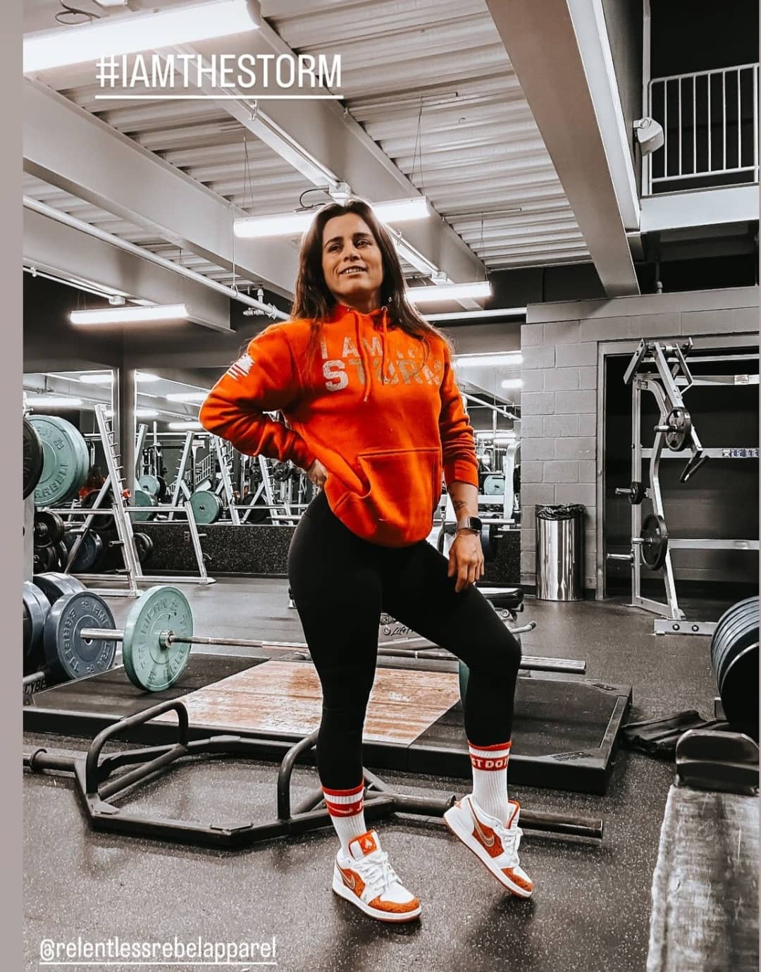 Woman in gym wearing Rebel Red Women's I Am The Storm Front Design Hoodie
