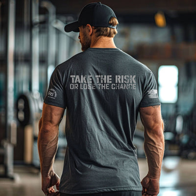 Man wearing a gray t-shirt with motivational text in a gym setting