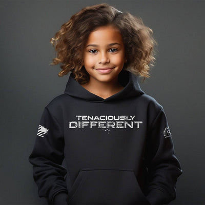 Child wearing a black hoodie with 'TENACIOUSLY DIFFERENT' text on a dark background