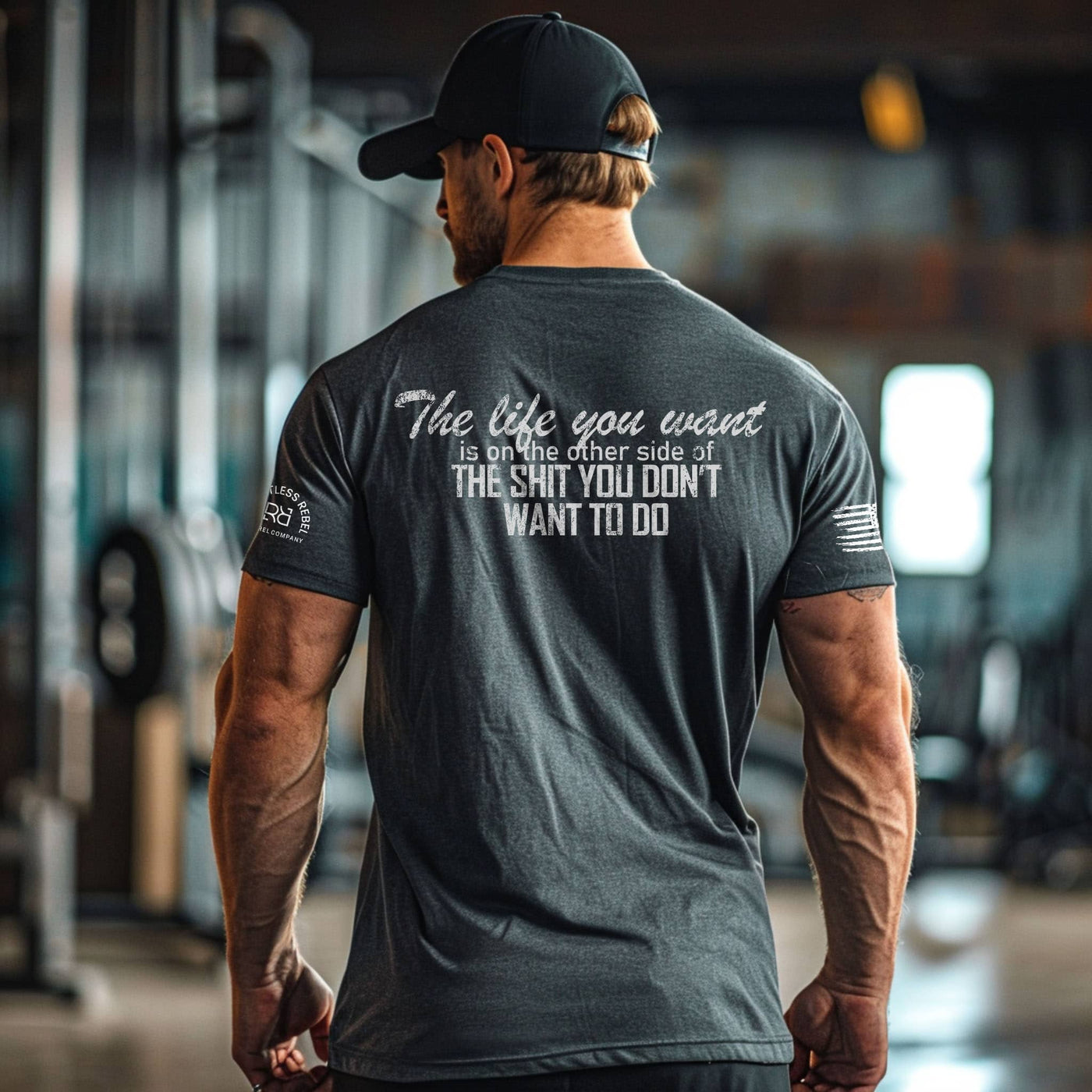 Man wearing a motivational t-shirt with text in a gym setting