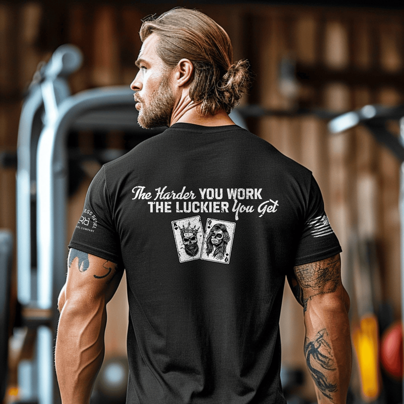 Man wearing a black t-shirt with motivational quote and graphics in a gym setting