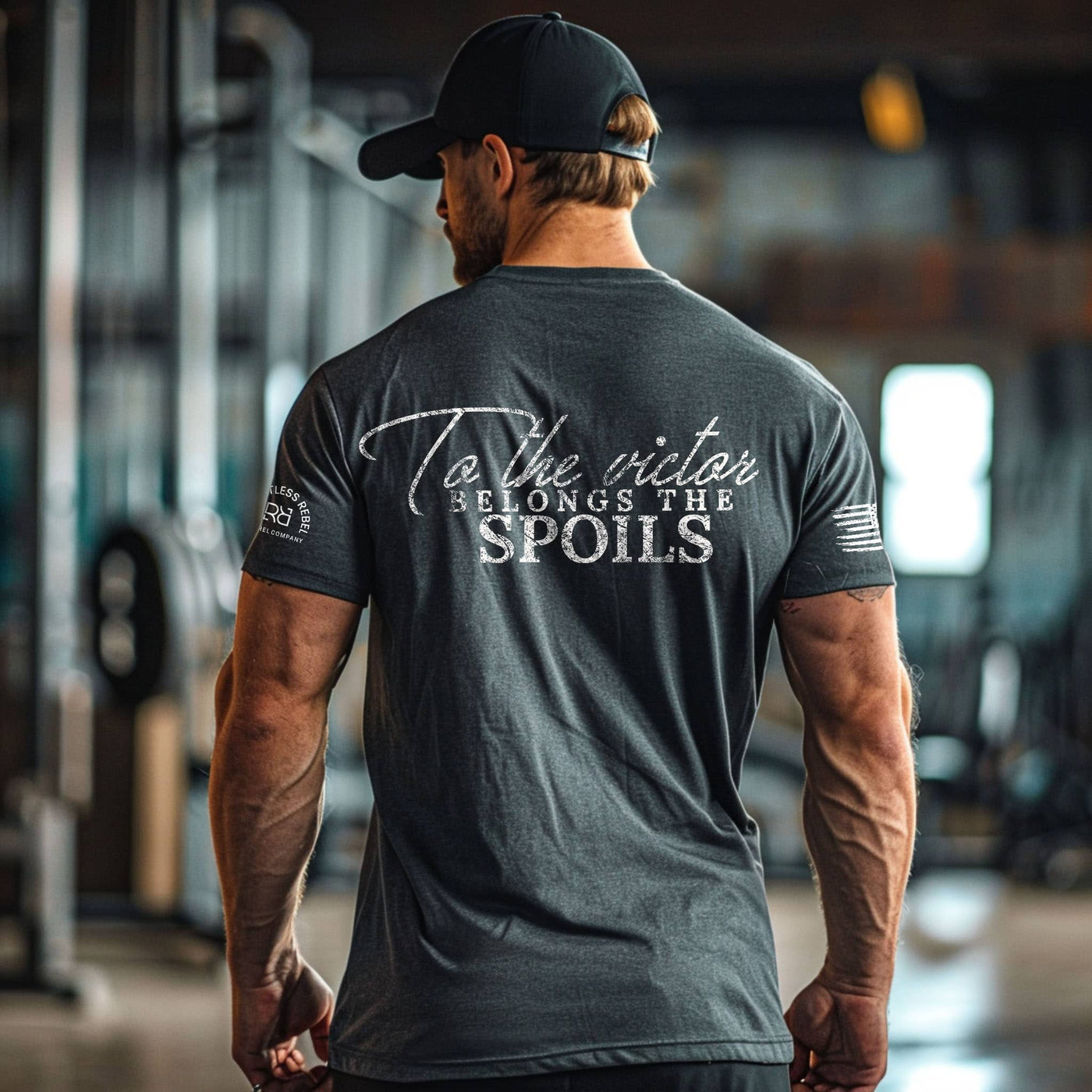 Man wearing a dark gray t-shirt with text on the back in an indoor setting