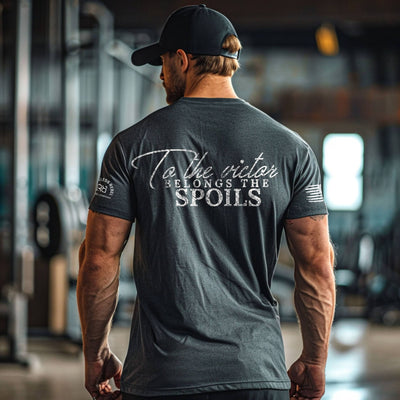 Man wearing a dark gray t-shirt with text on the back in an indoor setting