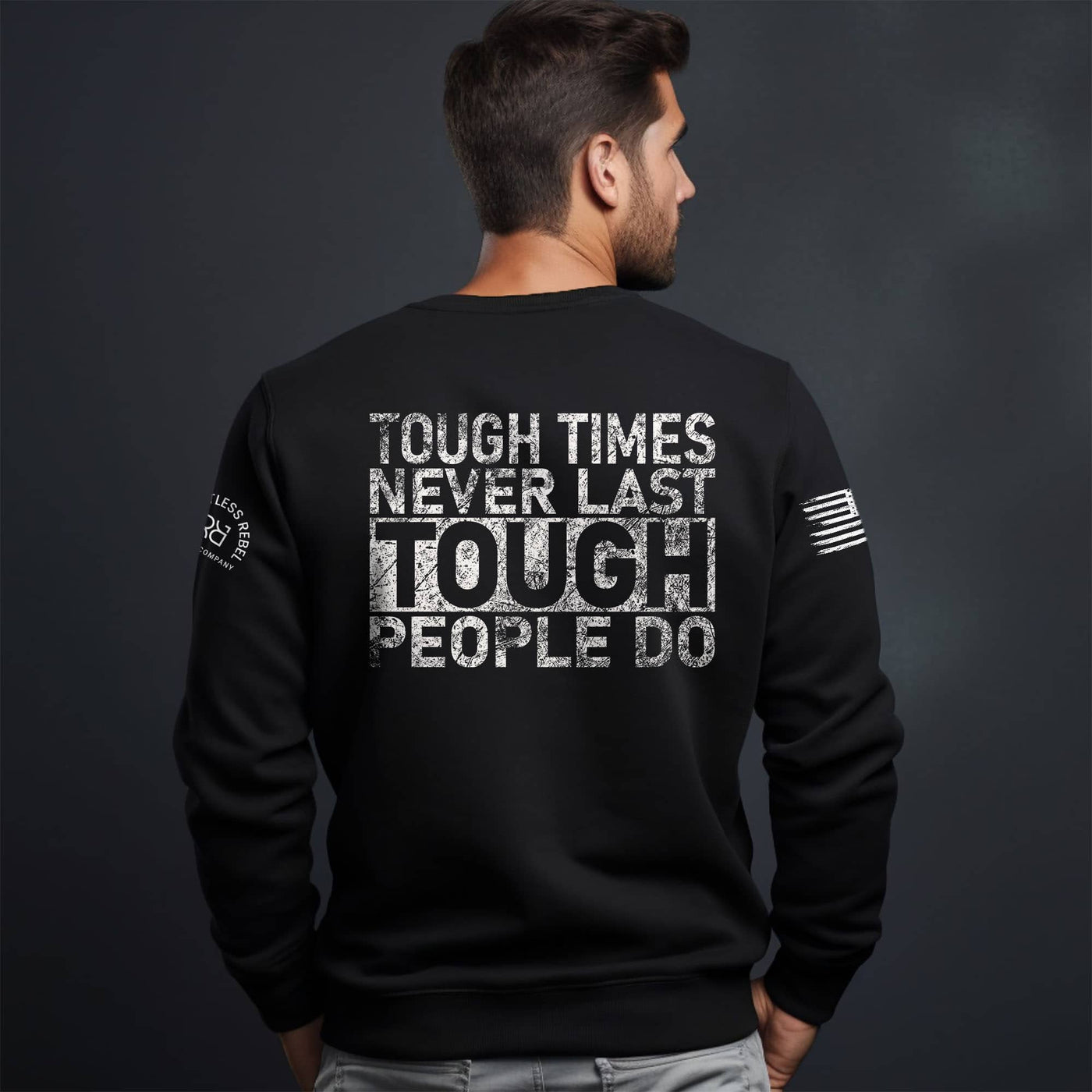 Man wearing a black sweatshirt with motivational text on the back against a dark background