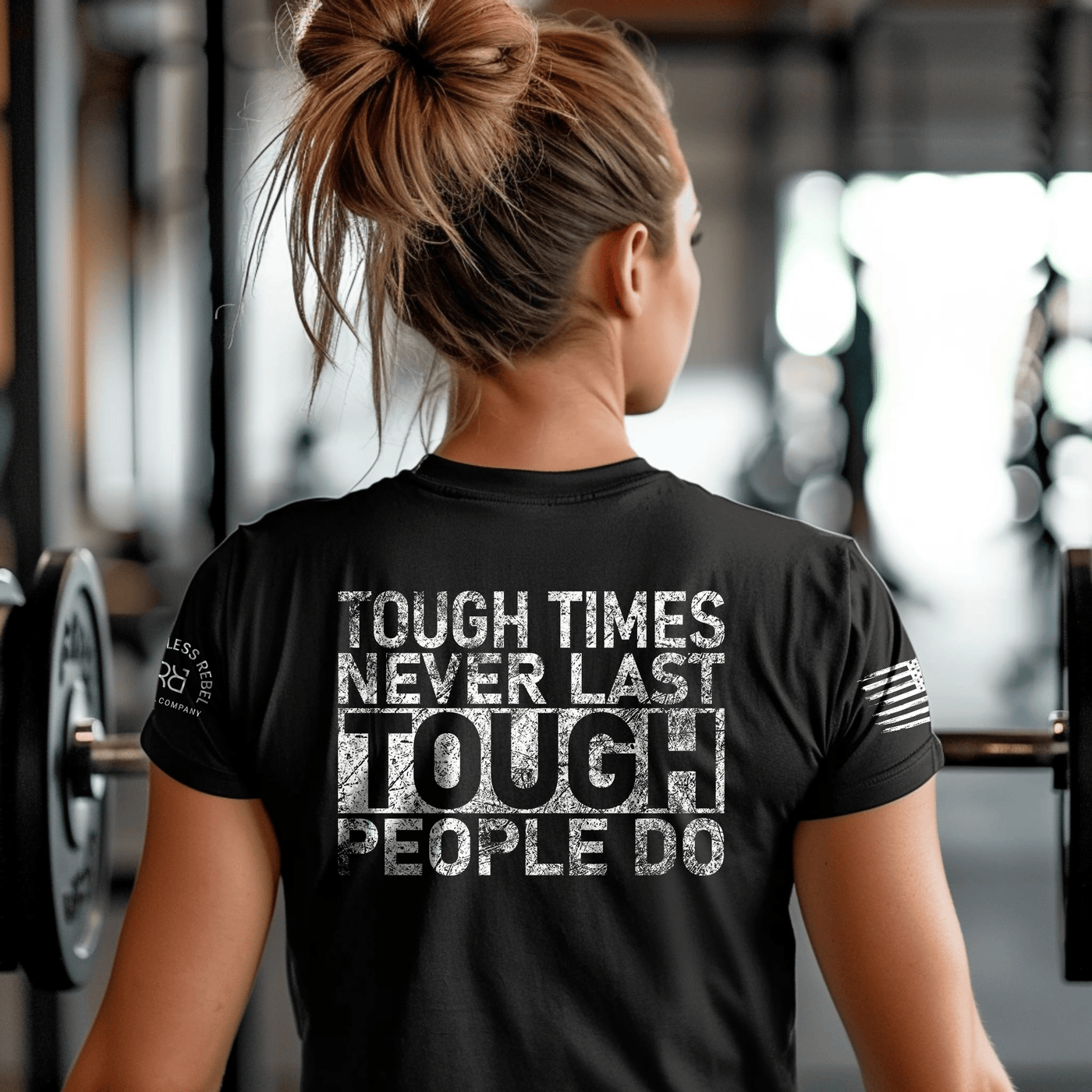 Person wearing a black t-shirt with motivational quote in a gym setting