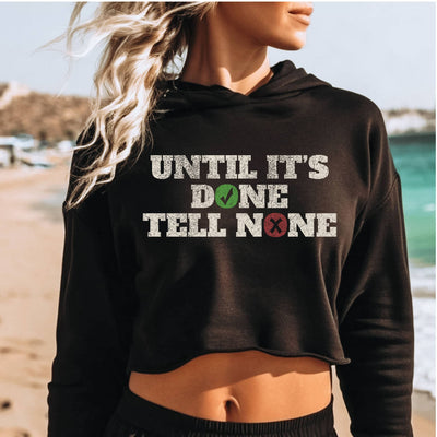 Person wearing a black hoodie with text on a beach