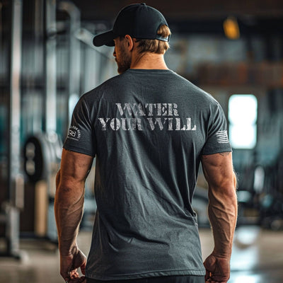 Man wearing a dark gray t-shirt with 'WATER YOUR WILL' text, standing in an indoor setting.