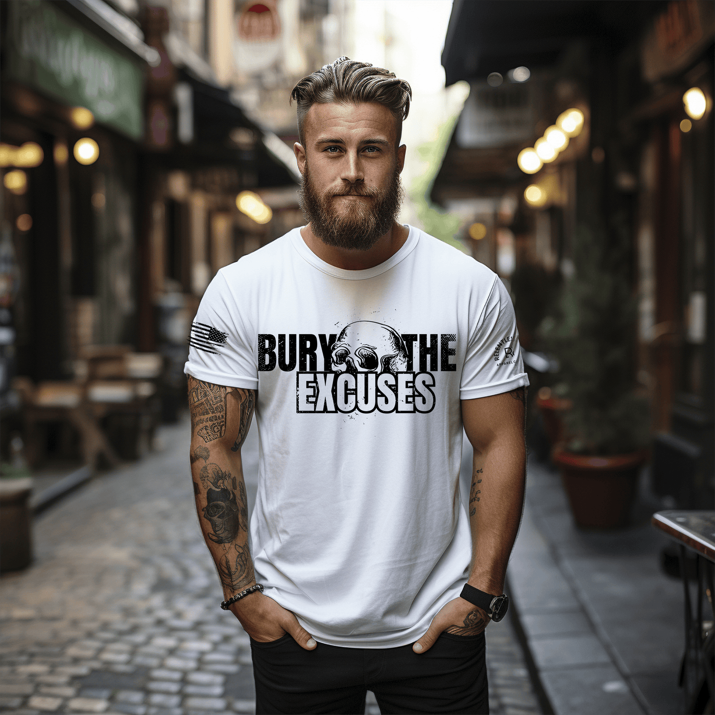Man wearing a white t-shirt with 'Bury The Excuses' text on a street.