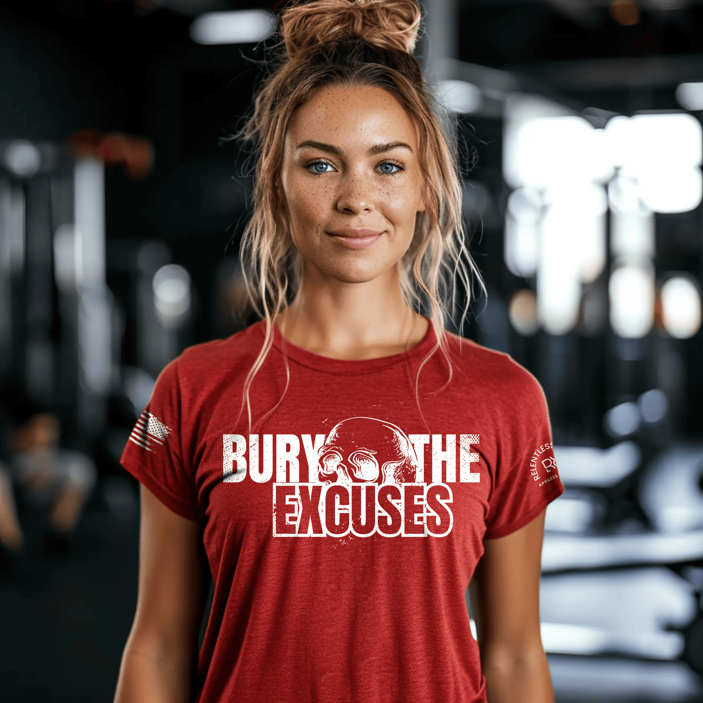 Woman wearing a red t-shirt with 'Bury The Excuses' text in a gym setting