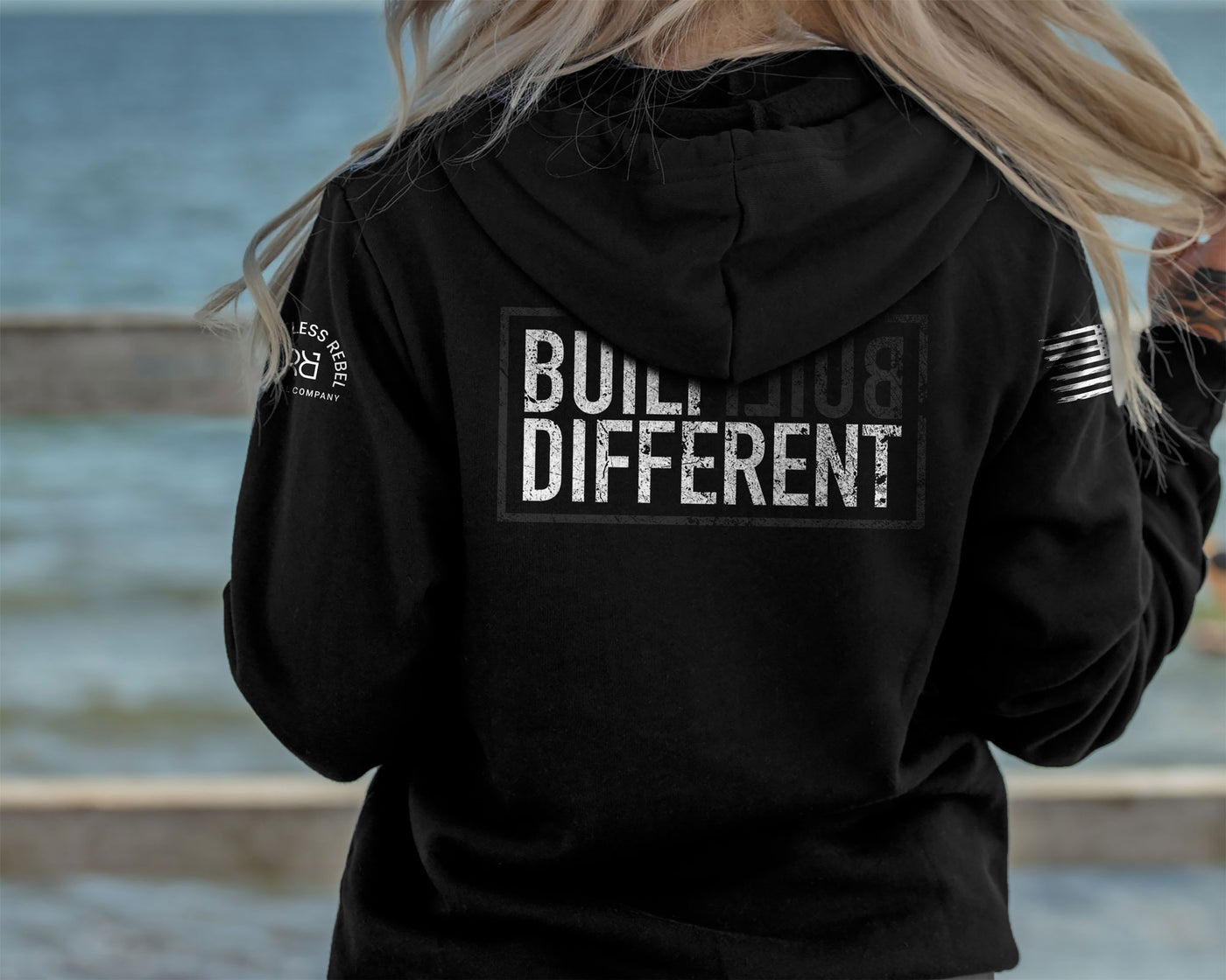 Woman wearing Solid Black Women's Built Different back design hoodie