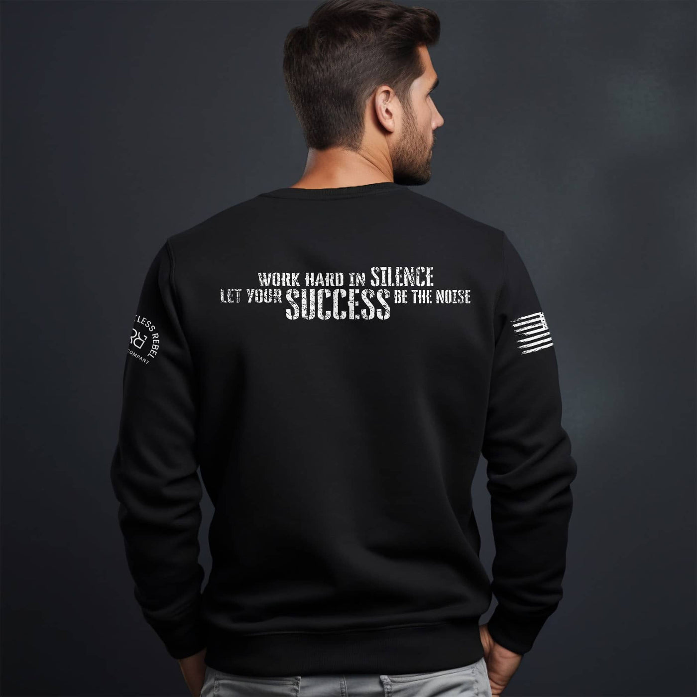 Black sweatshirt with motivational quote on the back worn by a person against a dark background
