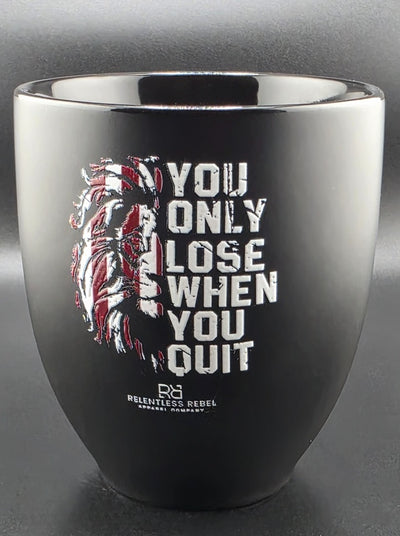 Black coffee mug with motivational quote and graphic design on a gray background